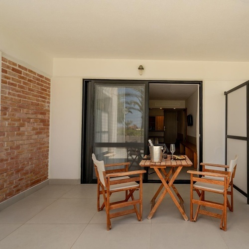 a patio with a table and chairs and a bottle of champagne
