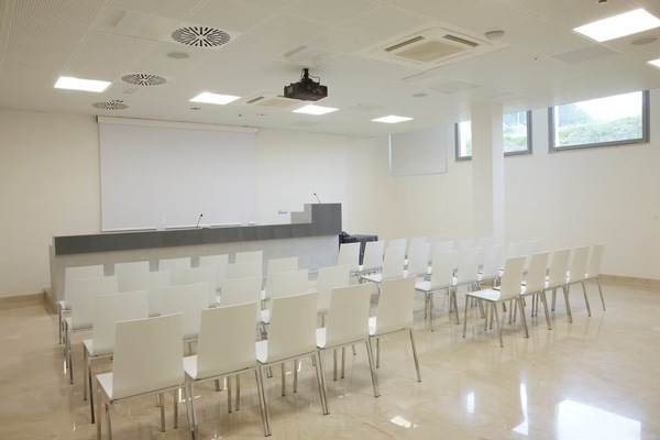 una sala de conferencias llena de mesas y sillas