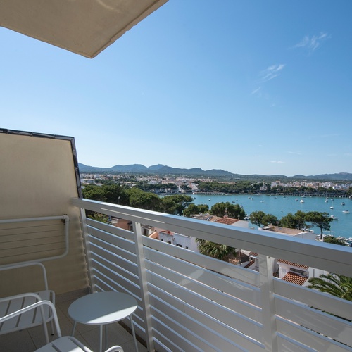 uma varanda com cadeiras e uma mesa com vista para um corpo de água