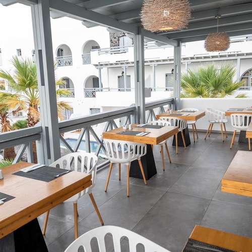 une salle à manger avec des tables en bois et des chaises blanches