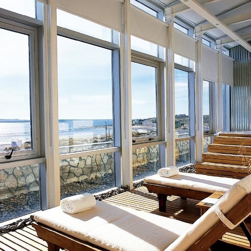 a room with a lot of windows and chairs with towels on them