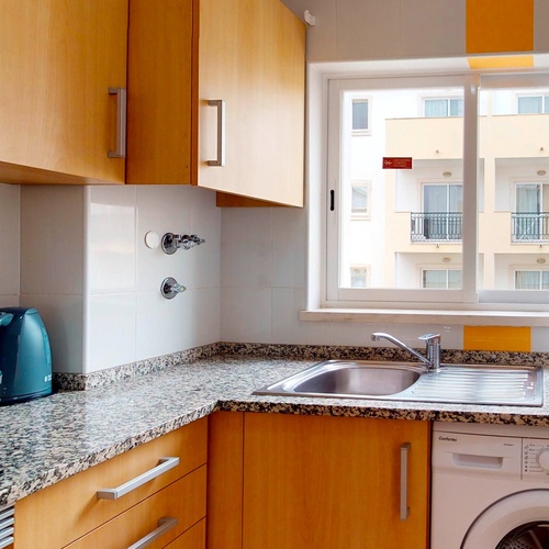 a kitchen with a washing machine and a microwave