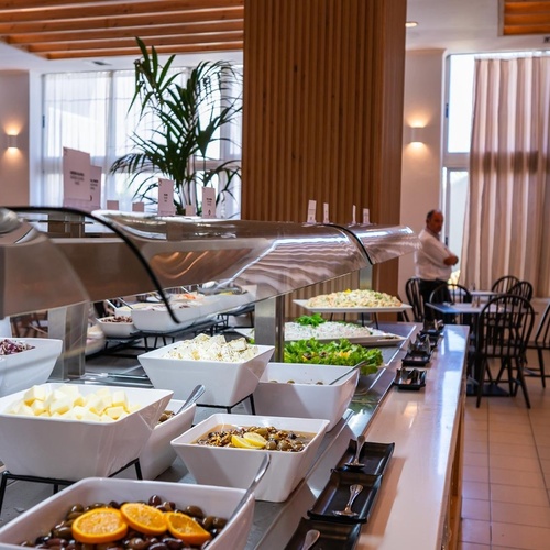 a buffet line in a restaurant with a man standing behind it