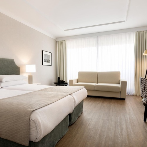 a hotel room with two beds and a couch