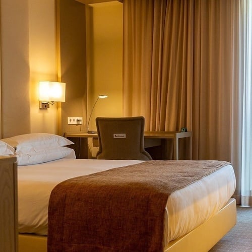 a hotel room with a large bed and a painting on the wall