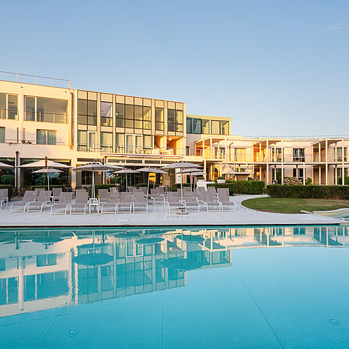 Piscine et hôtel ensoleillés, chambres élégantes et chaises longues au bord de la piscine. Profitez du confort du Smy: Corporativa.