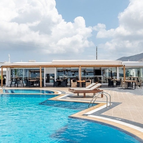 a large swimming pool surrounded by chairs and umbrellas