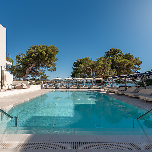 Modern hotel pool with sun loungers and Smy: Corporativa lounge area.