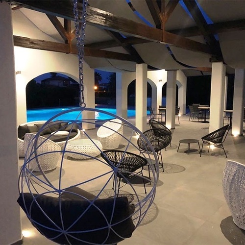 ein Wohnzimmer mit einem Swimmingpool im Hintergrund