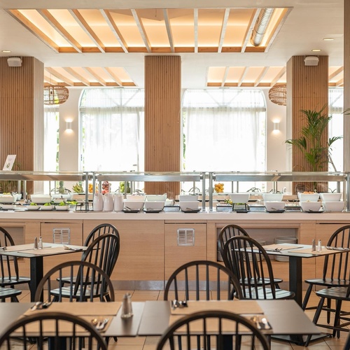 a restaurant with tables and chairs and a buffet line
