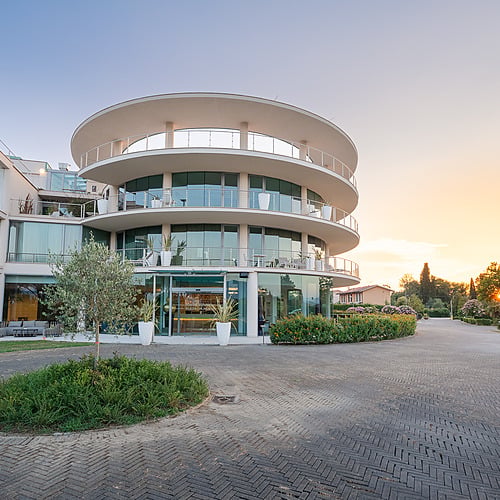 Hôtel @Smy: Corporativa@ au coucher du soleil, architecture moderne avec balcons circulaires.