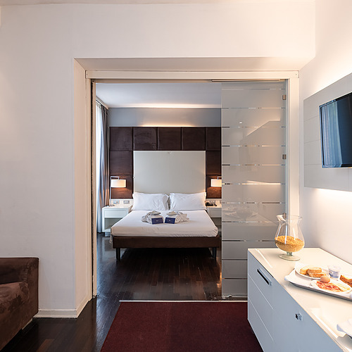 Chambre d'hôtel avec lampe moderne, table de chevet et lit, parfaite pour les séjours Smy: Corporativa.