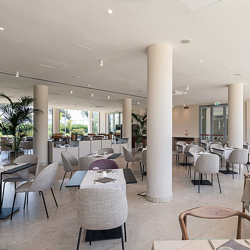 Salle à manger élégante de Smy: Corporativa avec tables dressées, chaises confortables et grandes fenêtres lumineuses.