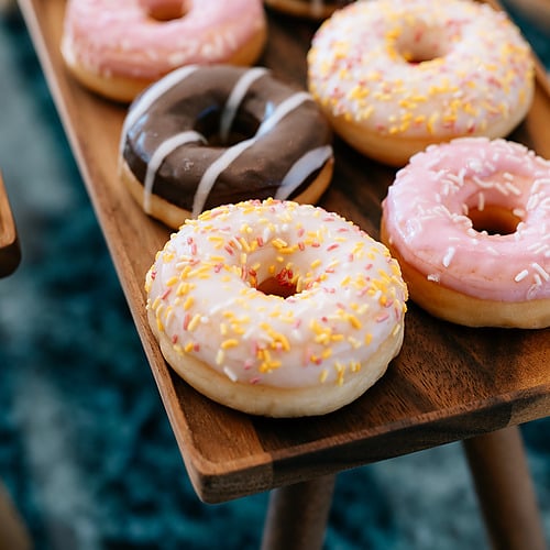 Plateau de donuts glacés et décorés, un délice sucré parfait pour votre pause gourmande Smy: Corporativa.