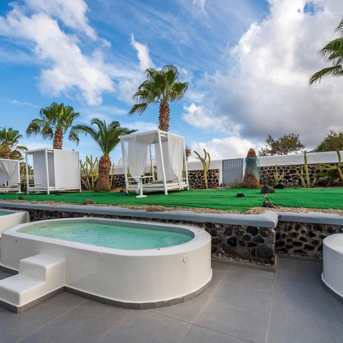 un groupe de jacuzzis blancs entourés de palmiers