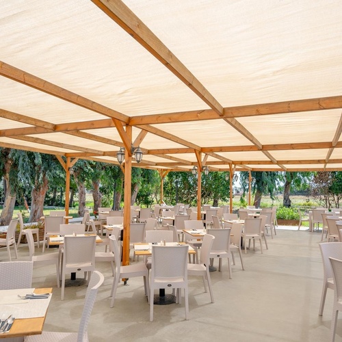 a restaurant with tables and chairs under a canopy