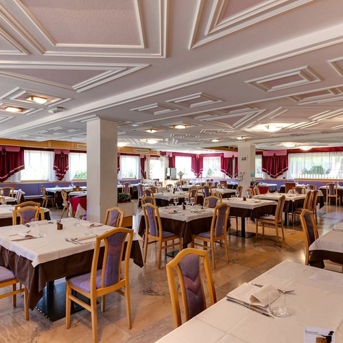 a large dining room with tables and chairs and a purple ceiling