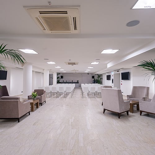 Salle de conférence moderne avec fauteuils et plantes, parfaite pour vos réunions Smy: Corporativa.