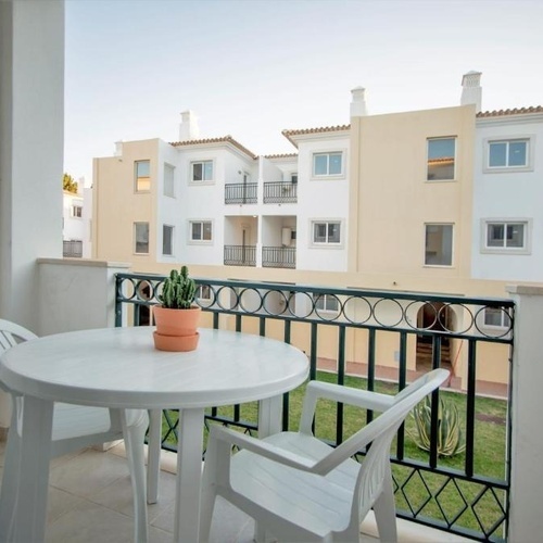 a balcony with a table and chairs and a potted plant