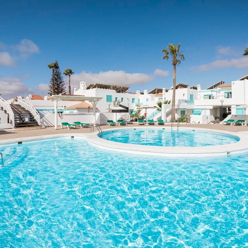 ein großer Swimmingpool vor einem weißen Gebäude