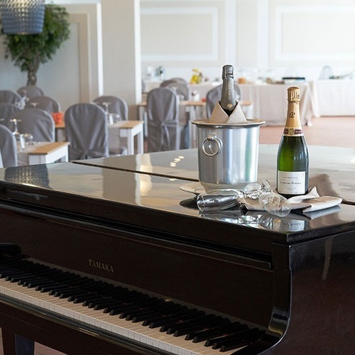 ein yamaha-Klavier mit einer Flasche Champagner darauf
