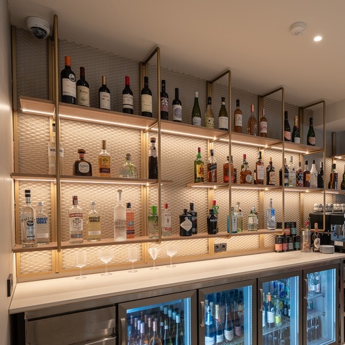Bar do hotel Smy: Corporativa com garrafas premium e máquina de café.