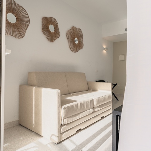 Sofá moderno bege em quarto de hotel, Smy: Corporativa.