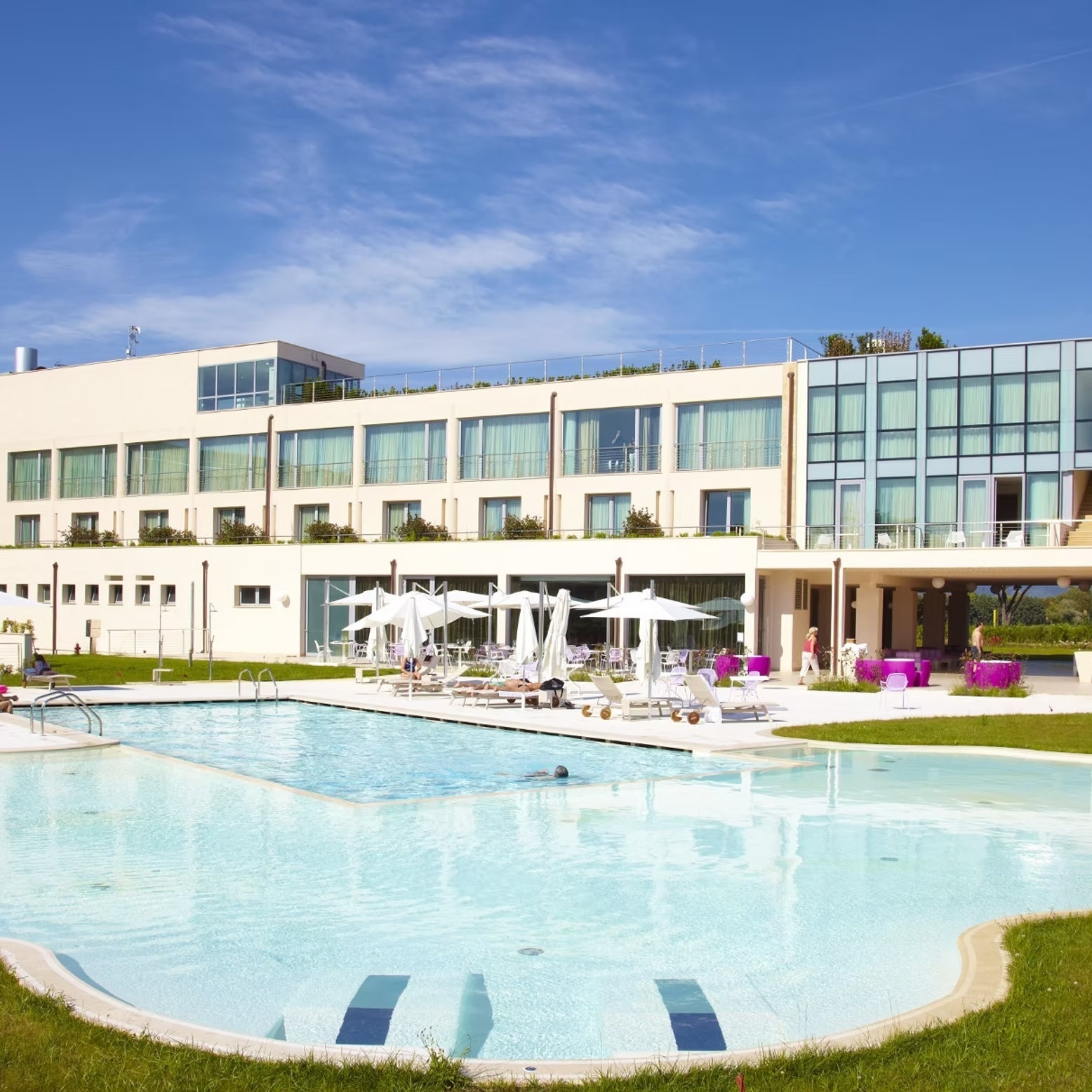 a glass of red liquid with a straw on the beach