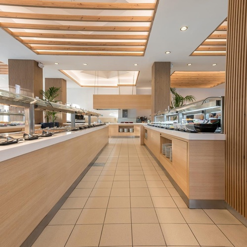 a long buffet line in a restaurant with a wooden ceiling