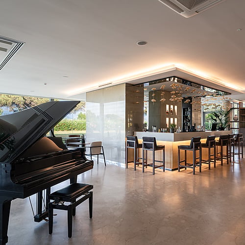 Grand piano and bar in a luxurious hotel lounge, perfect for Smy: Corporativa.