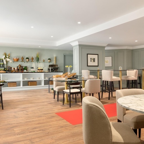 a dining room with tables and chairs and a buffet