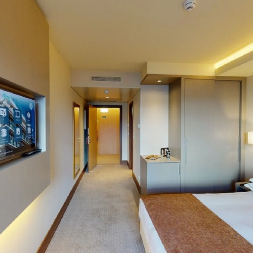 a hotel room with a large flat screen tv on the wall