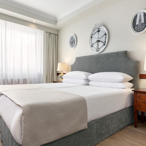 a hotel room with two beds and a clock on the wall