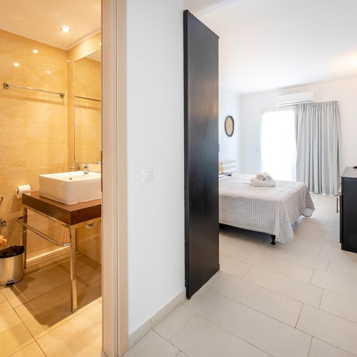 ein Badezimmer mit einem Waschbecken neben einem Bett