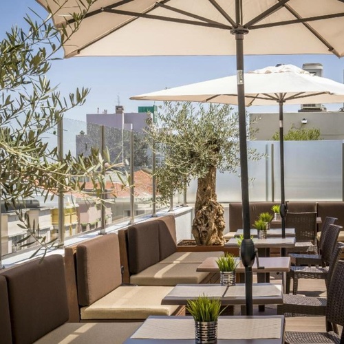 a patio with tables and chairs and an umbrella