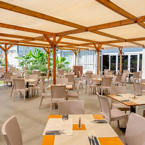 a restaurant with tables and chairs under a canopy