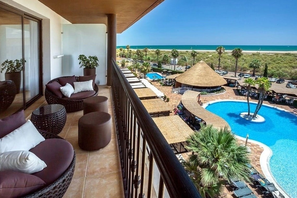 una piscina rodeada de palmeras y edificios blancos