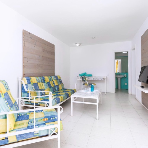 ein Wohnzimmer mit einer Couch und zwei Stühlen