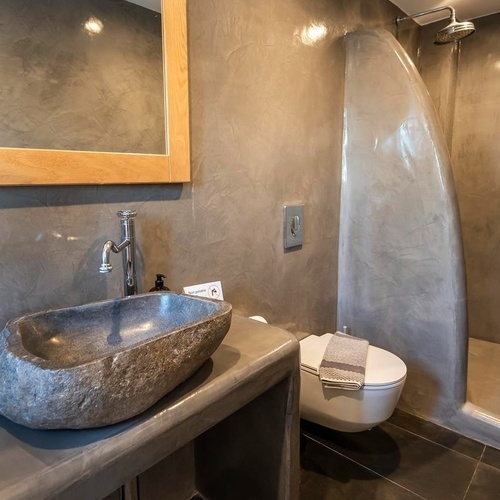 une salle de bain avec un lavabo en pierre et une toilette