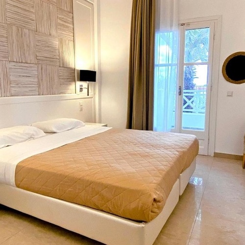 a hotel room with a large bed and a chair