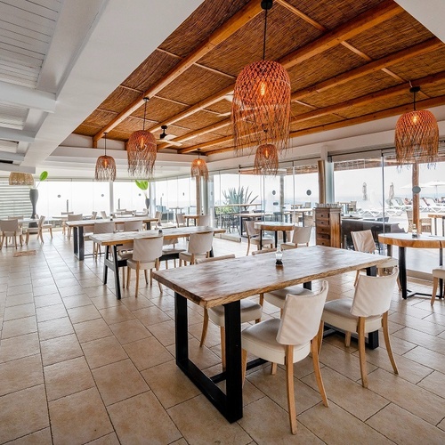 a restaurant with tables and chairs and a view of the ocean