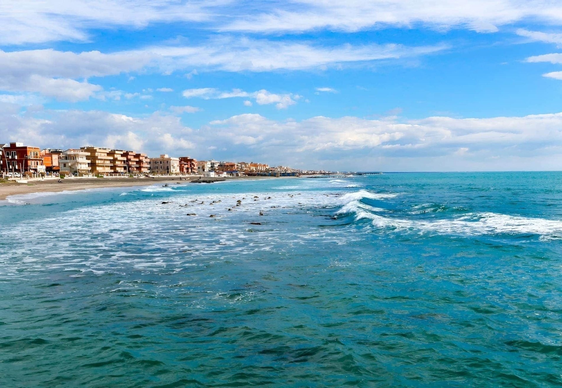a patio with tables and chairs surrounded by potted plants