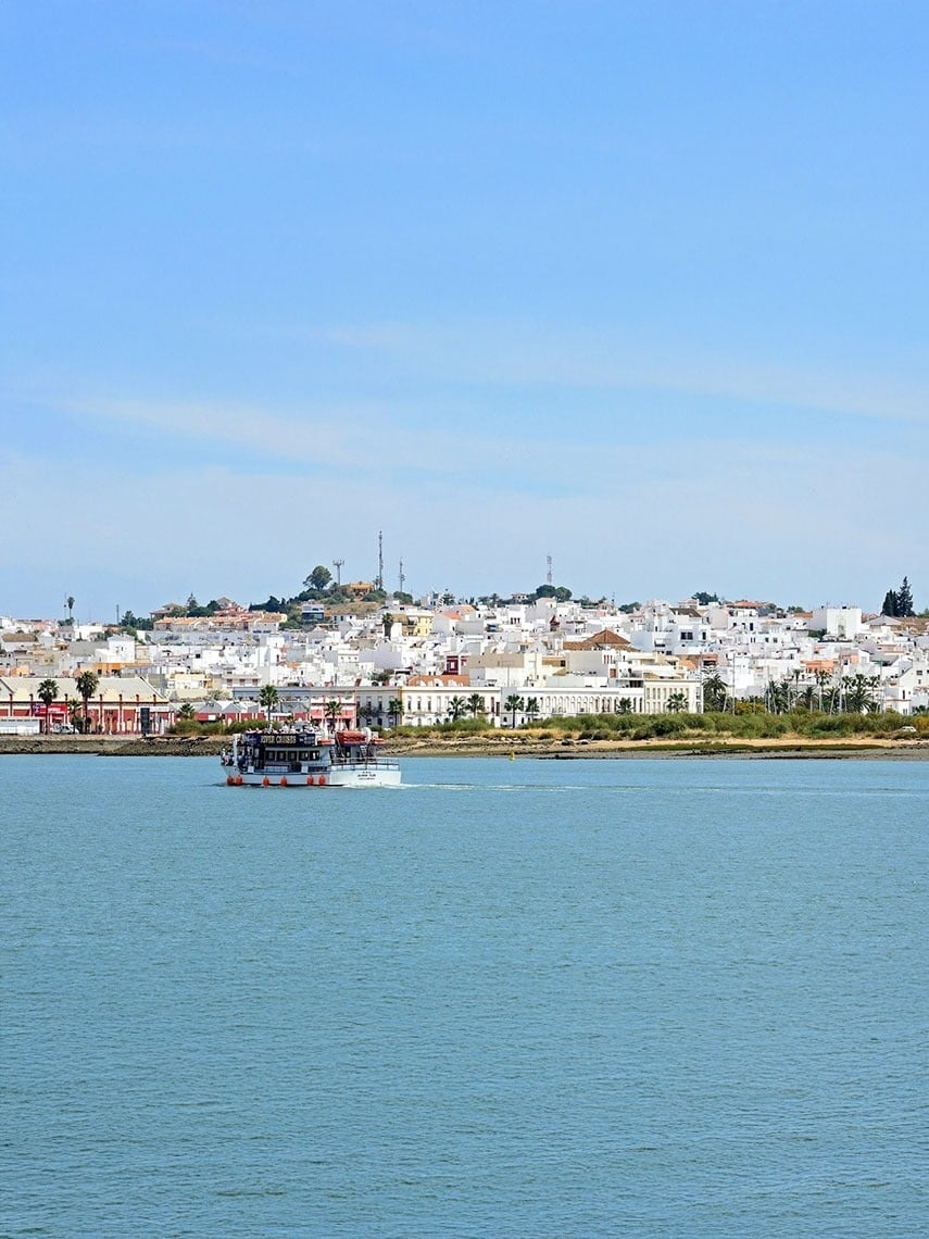 una mujer sentada en un muelle mirando al océano