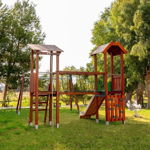 a wooden playground with trees in the background