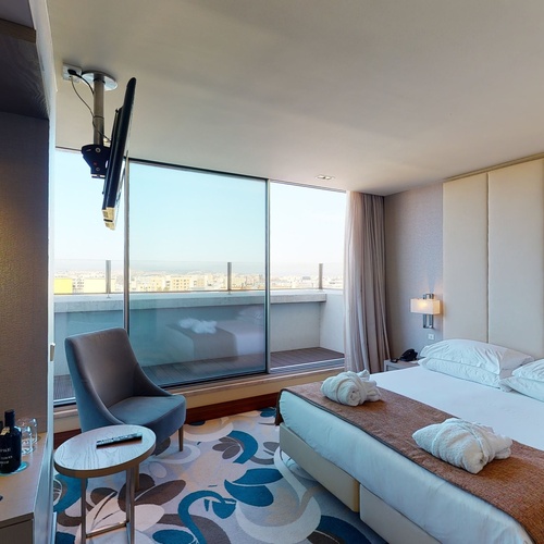 a hotel room with a king size bed and a chair