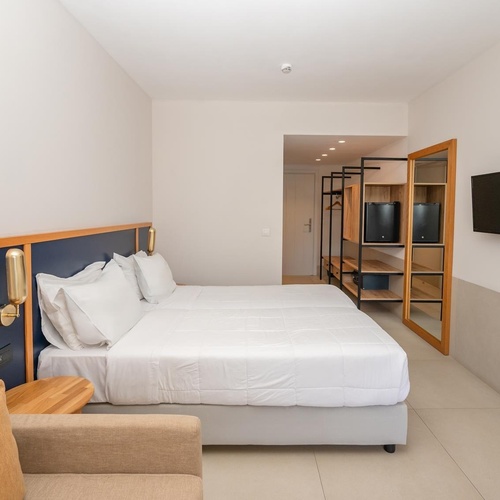 a hotel room with two beds and a flat screen tv