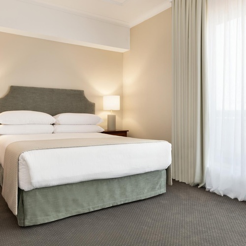 a hotel room with a bed and two lamps