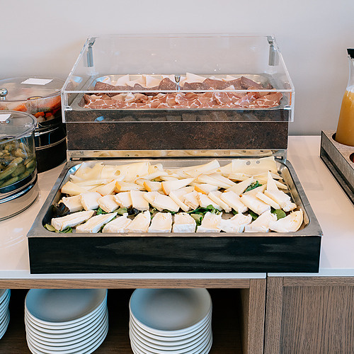 Buffet de petit-déjeuner avec charcuterie, fromages variés et plates. Idéal pour un séjour Smy: Corporativa.