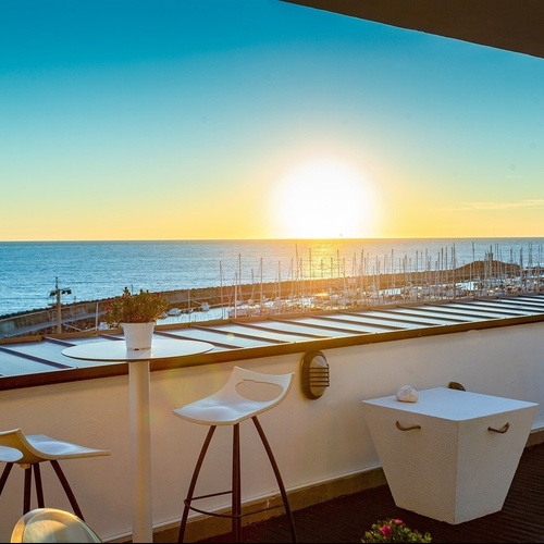 a large swimming pool surrounded by chairs and umbrellas