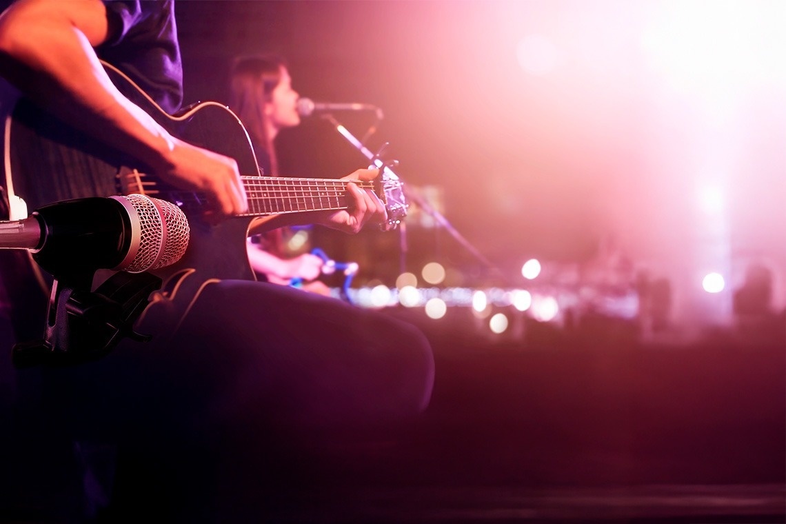 a glass of red liquid with a straw on the beach